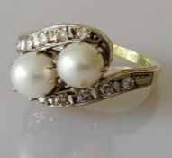 An Art Deco-style pearl and diamond crossover ring on white and yellow gold