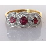 A yellow gold three-stone ruby ring, the central stone approximately 0.20 carats