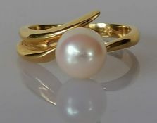 A single stone ring set with a round cultured pearl, measuring approx. 8mm, light cream colour