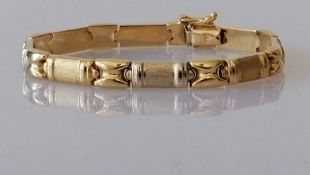 A gold link bracelet with alternating brushed and polished gold links, stamped 750