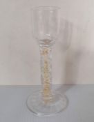 An Edwardian liqueur glass with faceted stem, gold foil inclusions and optical ribbing