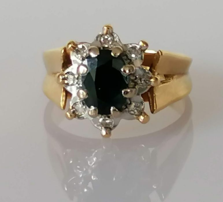 A vintage sapphire and diamond cluster ring, the claw-set central oval-cut sapphire
