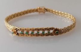 An Italian yellow gold woven bracelet with emerald decoration by Unoaerre, stamped 750, 16.63g