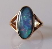 A 14ct gold black opal dress ring, the oval black opal triplet in bezel setting and forked shoulders