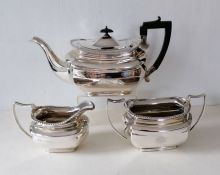 An Edwardian silver tea service with gadroon borders, harp-shape ebonised handle to teapot