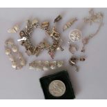 A silver charm bracelet, a 1951 silver crown and an assortment of other silver based jewellery, 145g