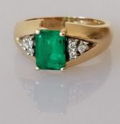 A synthetic emerald and diamond ring, the emerald-cut emerald measuring approximately 7.5 x 6.5 x 3.