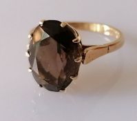 An oval smoky quartz ring on a 9ct gold claw setting, size P, the faceted stone 13 x 10mm, hallmarke