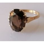 An oval smoky quartz ring on a 9ct gold claw setting, size P, the faceted stone 13 x 10mm, hallmarke