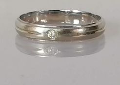 A diamond-set wedding band, rub-over setting, mounted on white metal