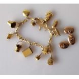 A yellow gold charm bracelet, 17 cm and 1 1/2 oval rose gold cufflinks