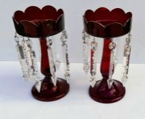 A pair of Victorian ruby glass lustre vases with hollow baluster stem, domed base