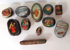 An assortment of ten Russian lacquered trinket boxes and a brooch from various traditions