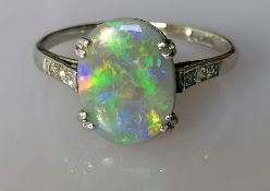 An Art Deco pinfire opal ring in a platinum and white gold claw setting