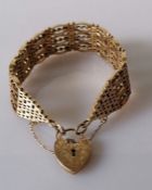 An elaborate yellow gold gate-link bracelet with chased heart clasp and safety chain, hallmarked