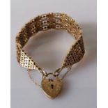 An elaborate yellow gold gate-link bracelet with chased heart clasp and safety chain, hallmarked