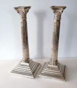 A pair of George V silver candlesticks in the Corinthian style, carved capitals, fluted columns