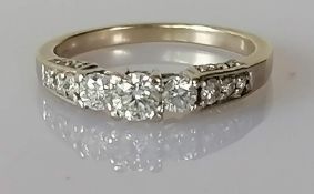 A 14ct white gold ring channel-set with eleven graduated round-cut diamonds,