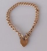 A rose gold curb-link chain bracelet with heart locket, 18 cm, unmarked, tests for 9ct, 9.45g