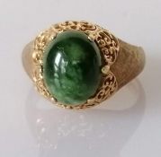 A jade oval cabochon gold ring, the jade stone approximately 10mm x 8mm