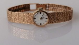 A ladies Jean Renet dress watch in a 9ct gold textured strap, hallmarked, 22.7g (without mechanism)