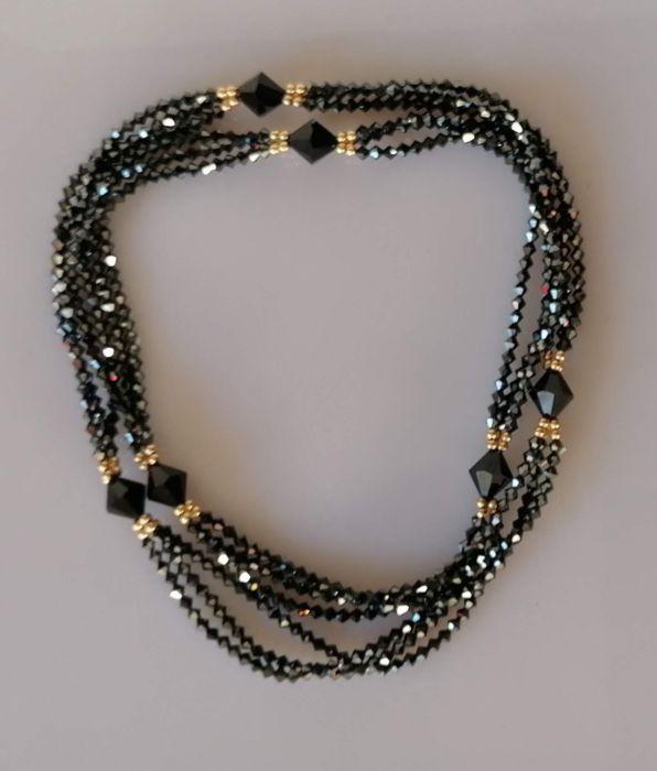An elegant triple-strand black cut bead necklace with matching bracelet, both with 9ct gold clasps