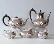 A late Victorian silver tea set comprising teapot, sugar bowl and jug of oval form with embossed dec
