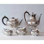 A late Victorian silver tea set comprising teapot, sugar bowl and jug of oval form with embossed dec