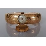 A vintage gold bangle with Imperios watch mechanism and articulated arms, 27.8g