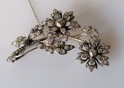 An Art Deco diamond spray brooch comprising a two-branch sprig with leaves and flowers