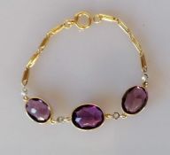 An 18ct yellow gold amethyst and diamond bracelet, 16.5 cm, with three mixed oval-cut amethysts