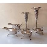 Two Indian-style silver trumpet-shape vases with embossed decoration, wavy rims, 18, 22 cm