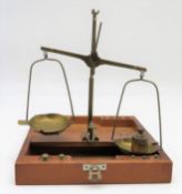 Balkenwaage mit Gewichten in Holzschatulle, 1. Hälfte 20. Jahrhundert, h 24 cm, d 21 cm.