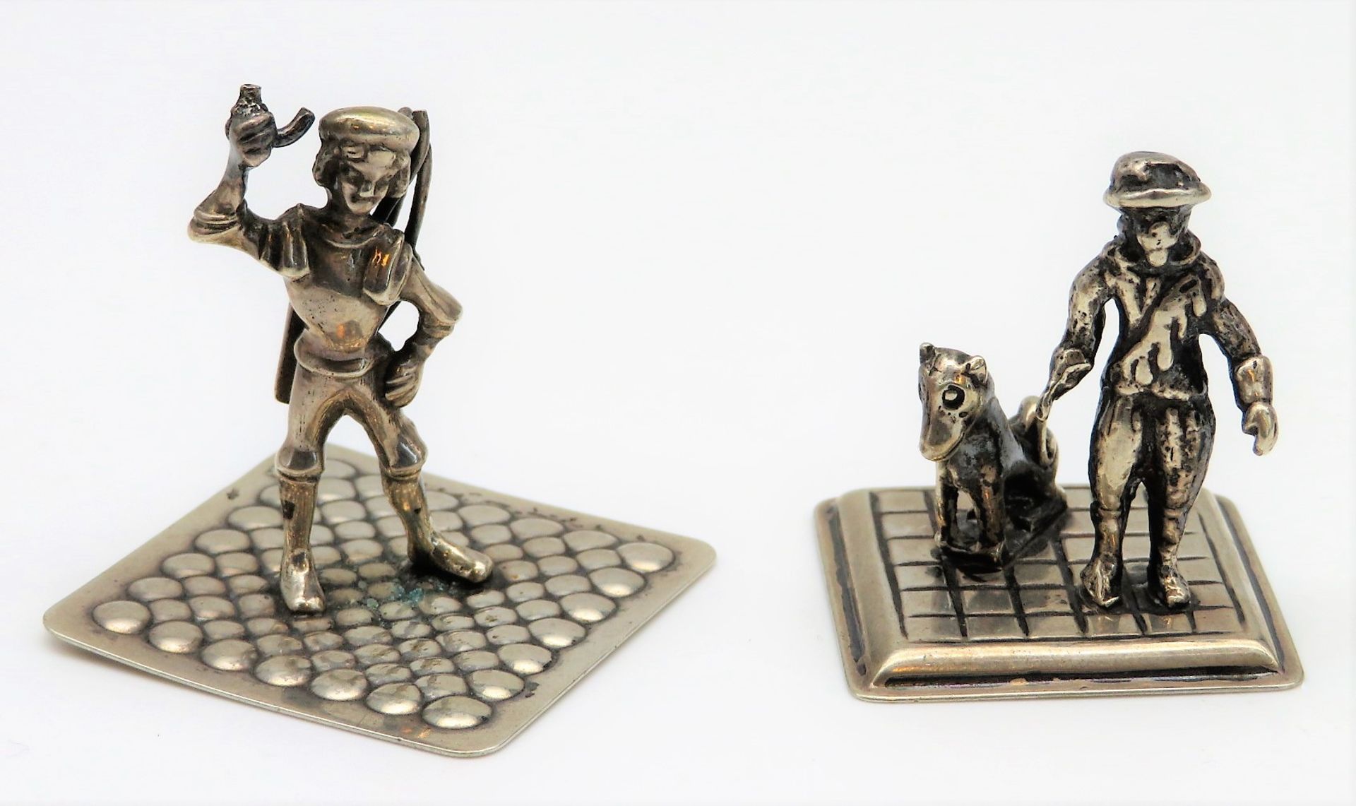 2 Miniatursilber Figuren, "Mann mit Hund" und "Verkäufer", 835er Silber, gepunzt, 29 g, h 3,3/3 cm.