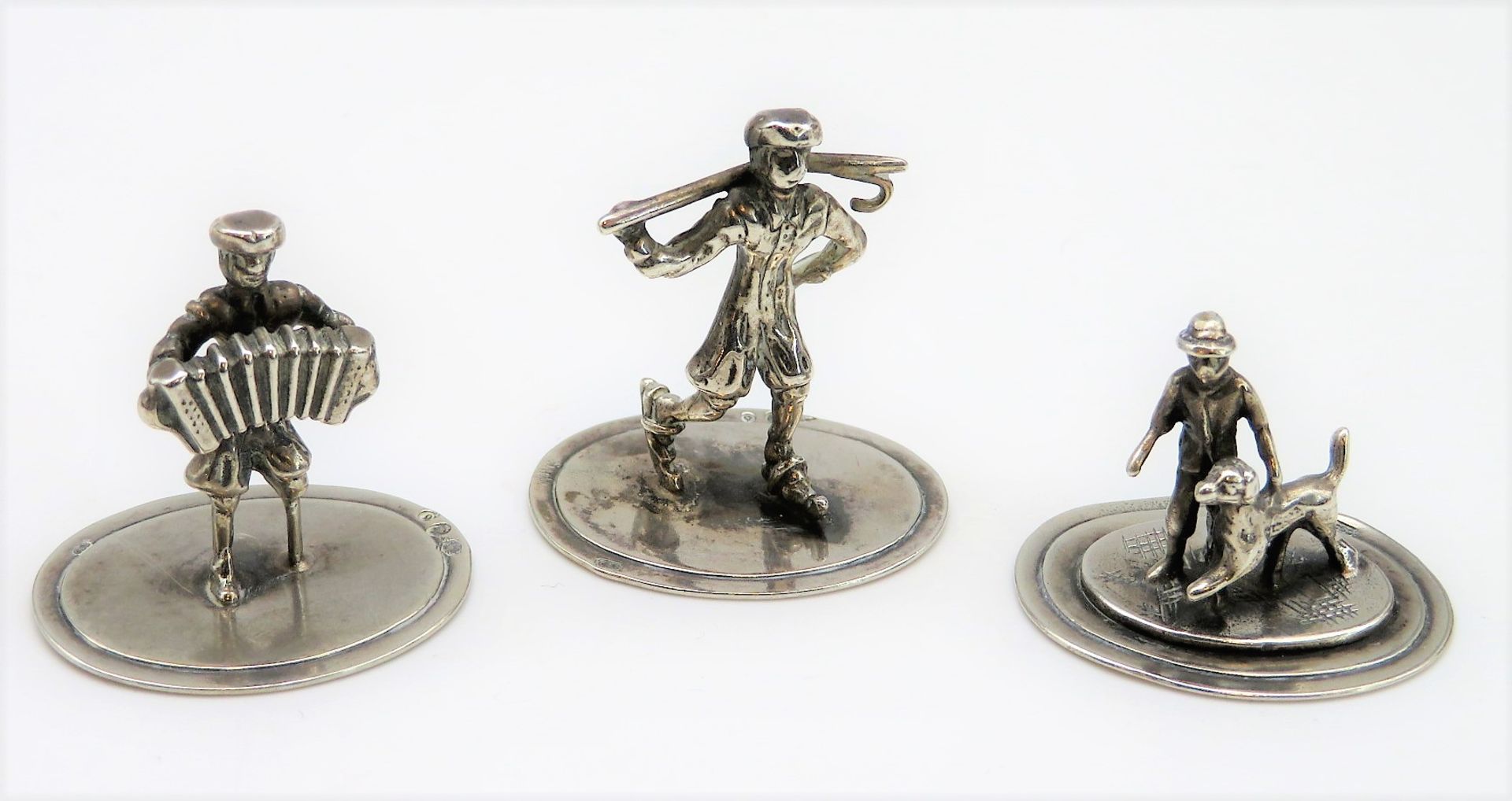 3 Miniaturfiguren, Schlittschuhläufer, Mann mit Ziehharmonika und Mann mit Hund, 835er Silber, gepu