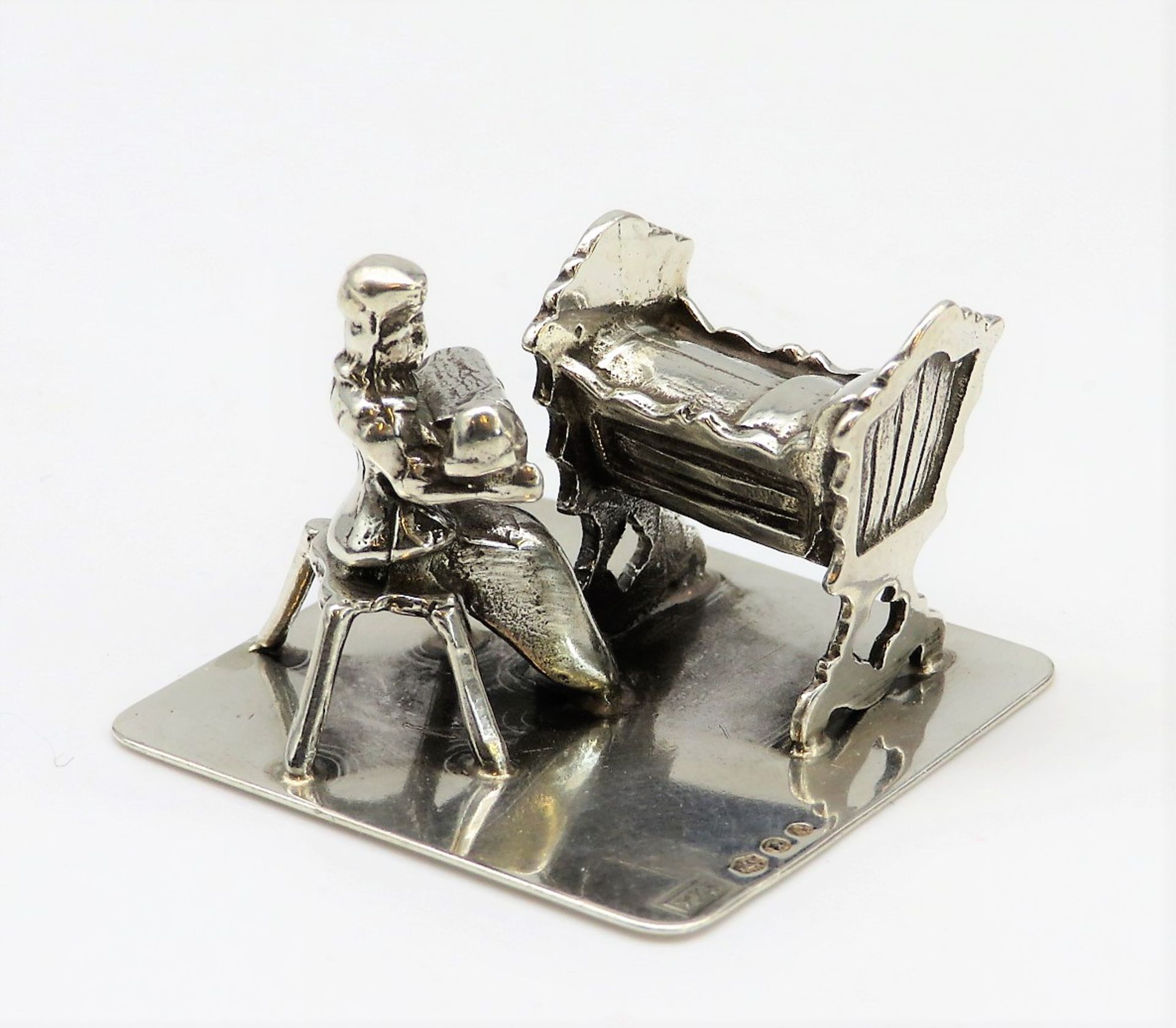 Miniatursilber, Mutter mit Kleinkind an der Kinderwiege, 835er Silber, gepunzt, 16,5 g, 2 x 3,2 cm.