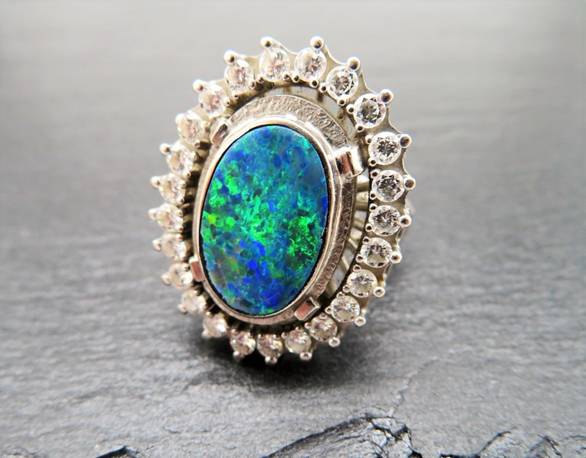 Entourage Ring, Opal, umrahmt von 24 Brillanten, zus.ca. 1,2 ct, TW VVSI, 585er Weißgold, gepunzt, 