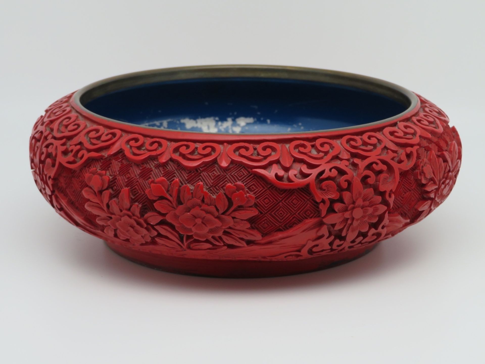 Schale, China, rote Chinalackarbeit reich geschnitzt, h 6,5 cm, d 19,5 cm.