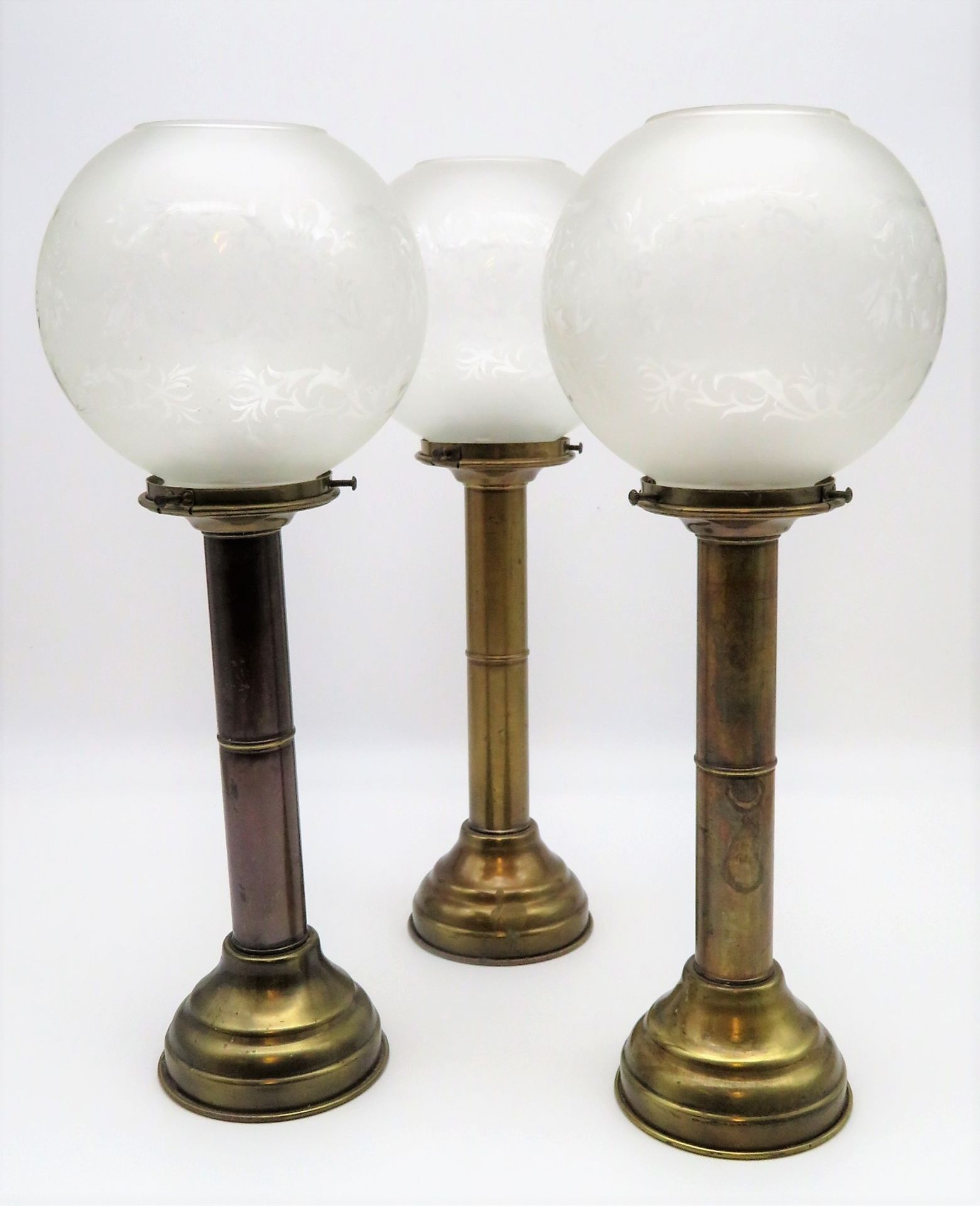 3 Kerzenleuchter, England, um 1900, Messing mit Glasschirmen, h 39 cm, d 16 cm.