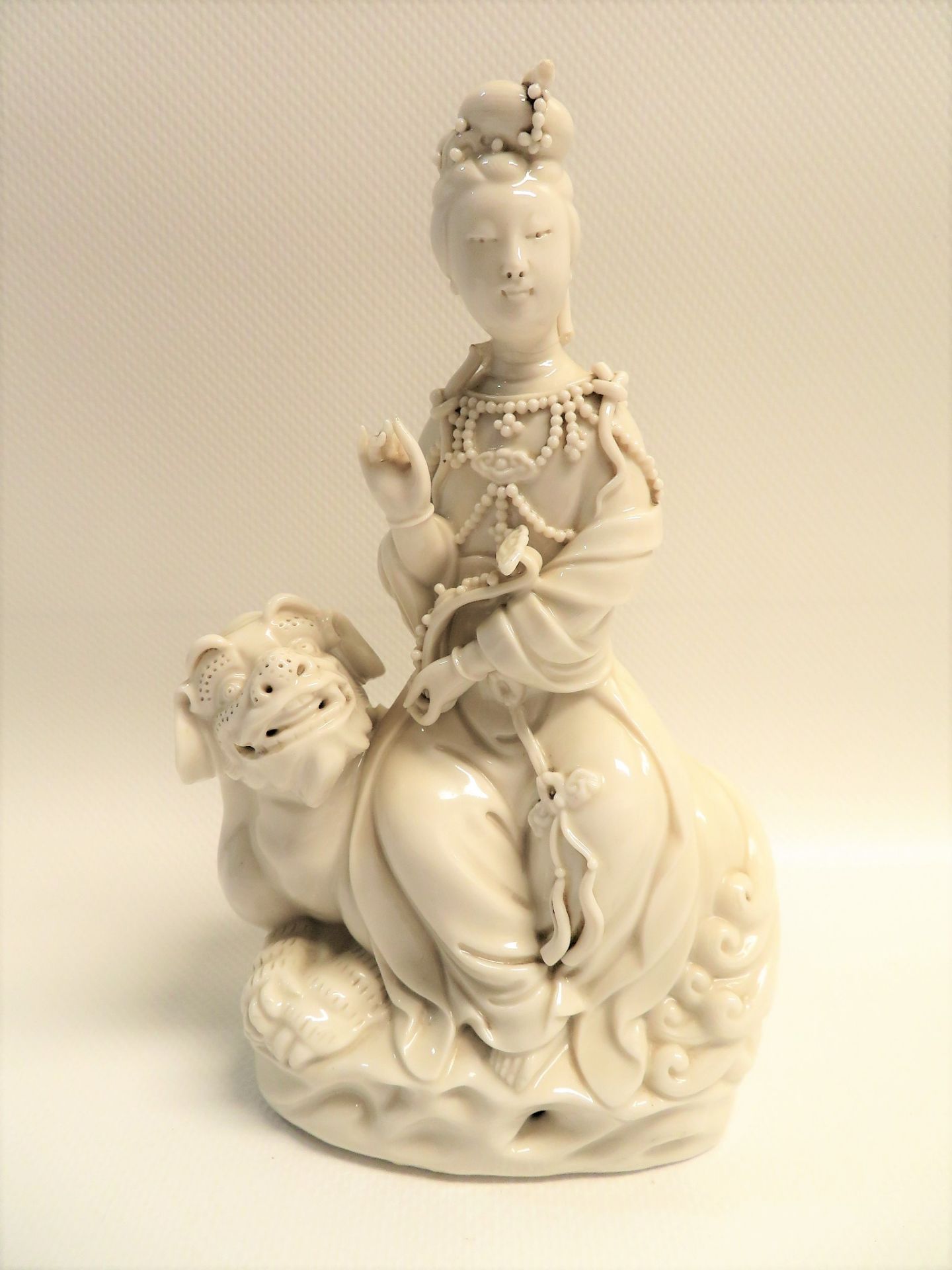 Sitzende Guanyin/Kwanyin auf Tempellöwen, China, Blanc de Chine/Weißporzellan, Kopf rest., h 16,5 c