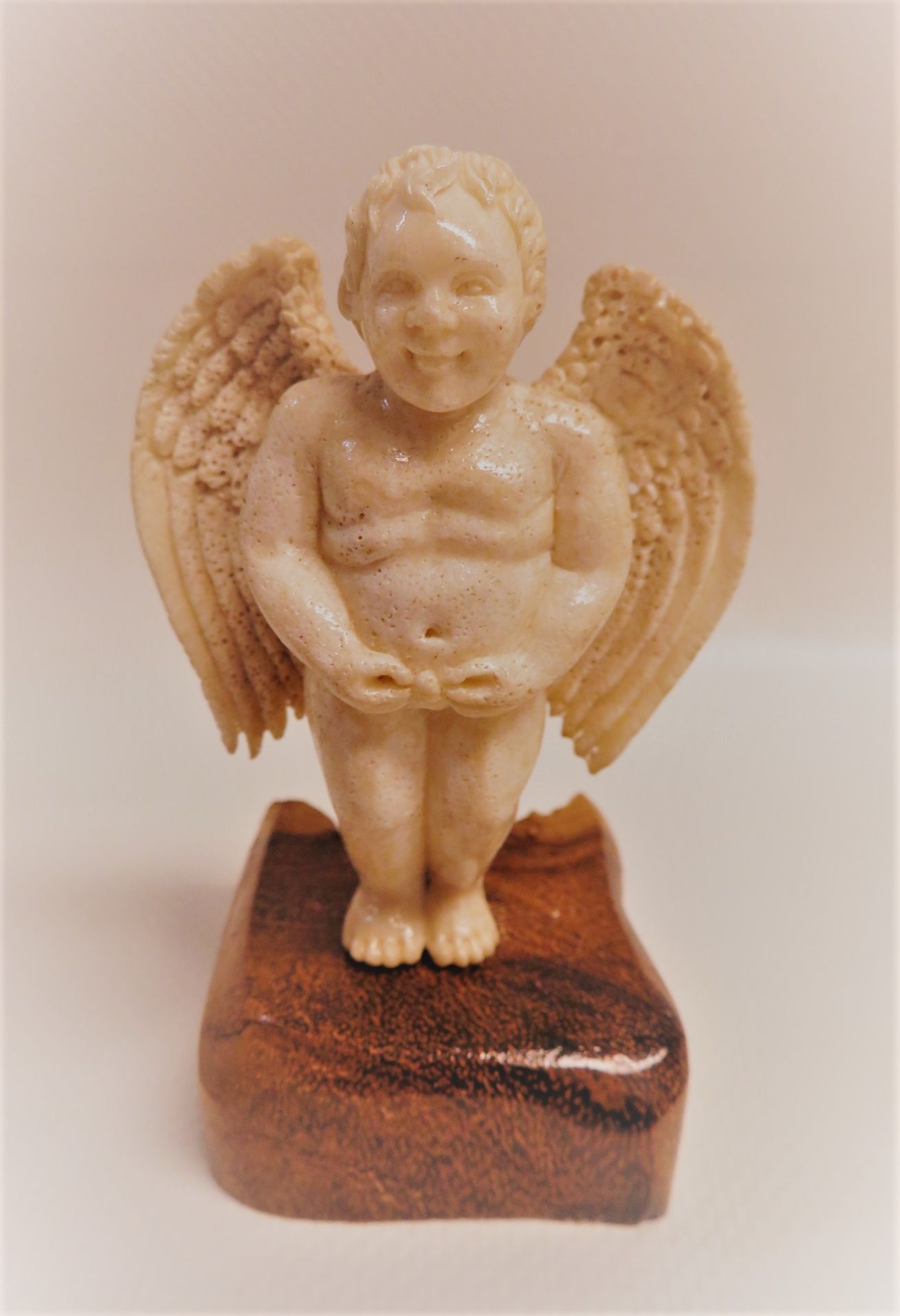 Stehender, geflügelter Putto, Horn geschnitzt, seinen "Lulumann" haltend", Holzsockel (h 2 cm), 6,5