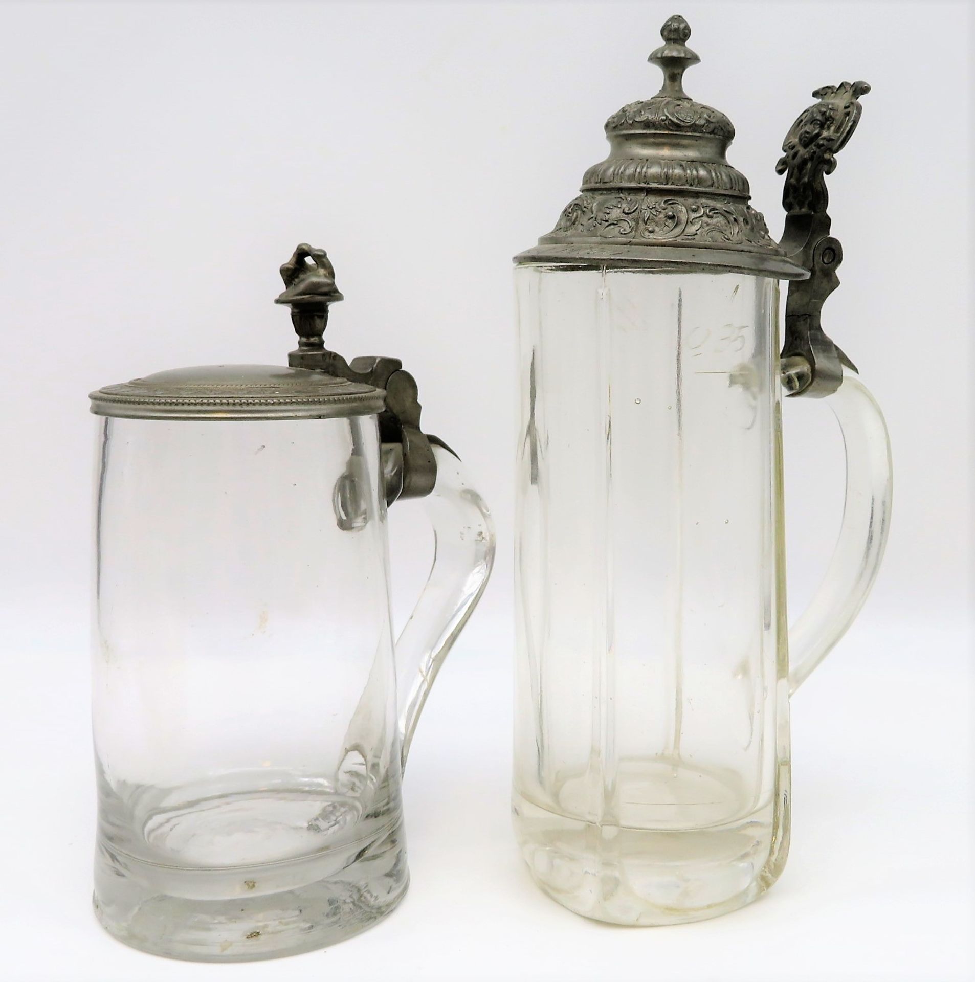 2 Bierkrüge, 19. Jahrhundert, farbloses Glas, Zinndeckel, h 18/23 cm.