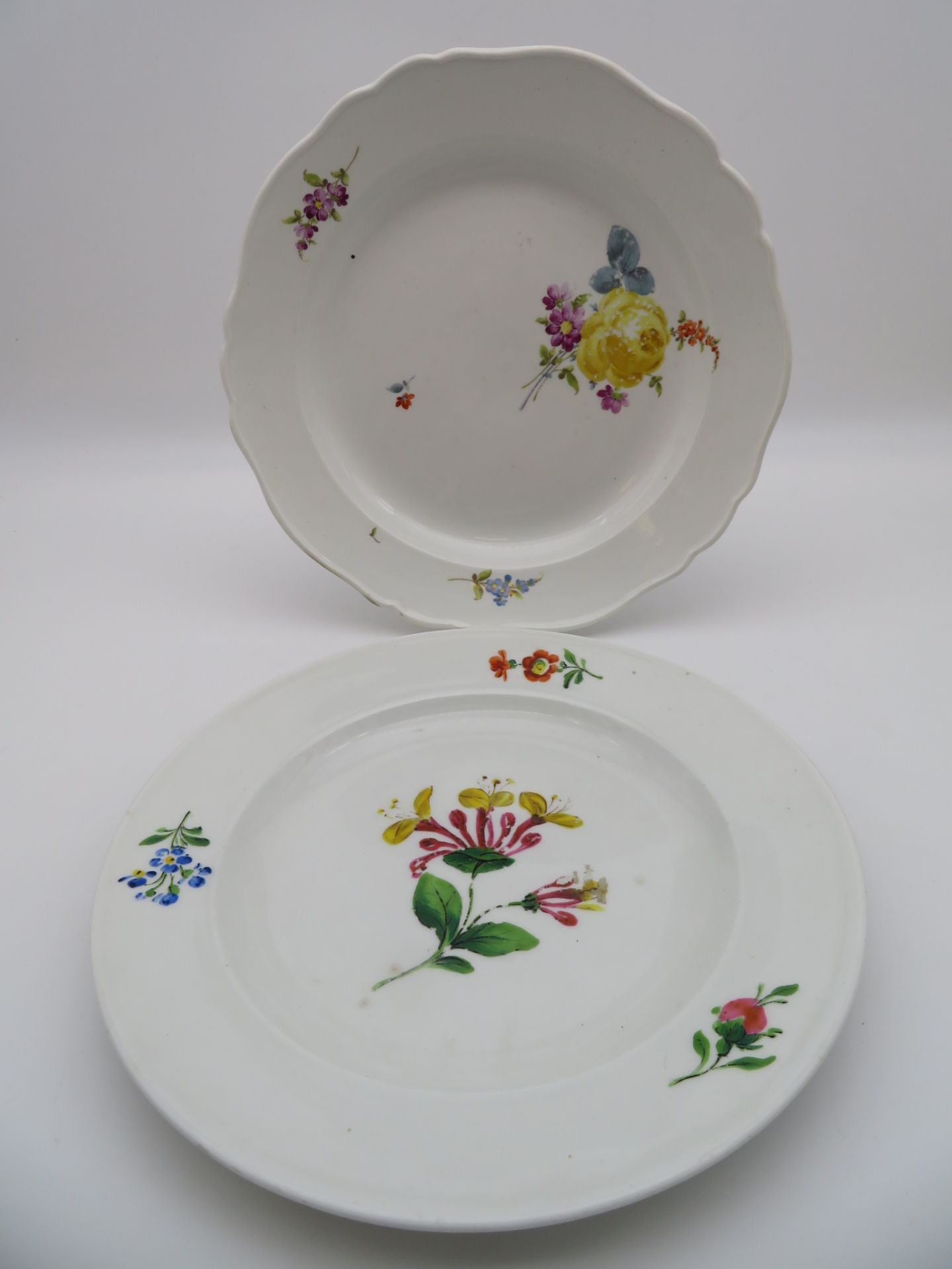 2 diverse Teller, Meissen, 1763 - 1774/1860 - 1924, Weißporzellan mit polychromer Blütenmalerei, 1 