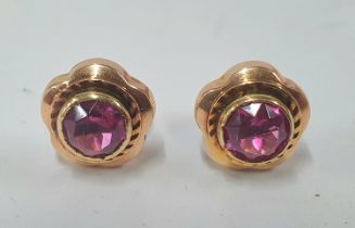 Pair of ladies 9ct Rose gold earrings containing a single circular ruby red glass centre, 2 grams