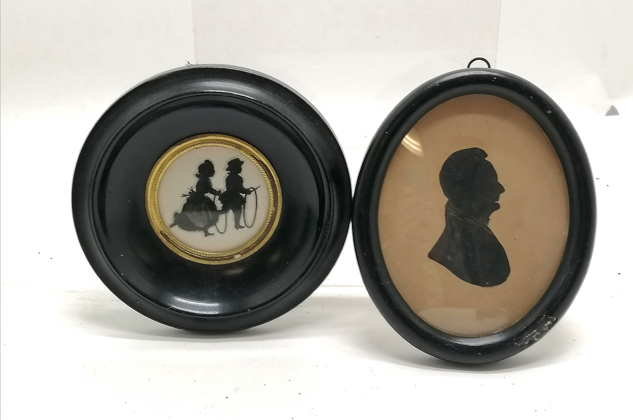 2 framed pen and ink silhouettes, circular framed of 2 children and an oval of a gentleman 15cm x