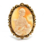 Antique hand carved shell cameo brooch of a seated lady in gilt metal mount - 5.9cm high and has