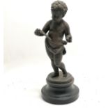 Spelter figure of a putti on a wooden base 28cm high. 1 finger missing