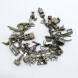 Silver charm bracelet with many charms inc sedan car, Chim opening car charm, sardine tin, flying