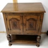 A reproduction oak court cupboard, with carved decoration, with shelf under, on bun feet. 77 cms