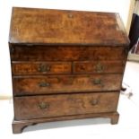 An Antique walnut fall front bureau, revealing pigeon hole interior, and secret drawers, on 2